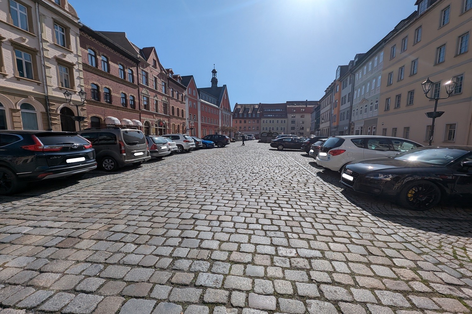 Parkende Autos auf dem Marktplatz in Kahla an einem sonnigen Tag